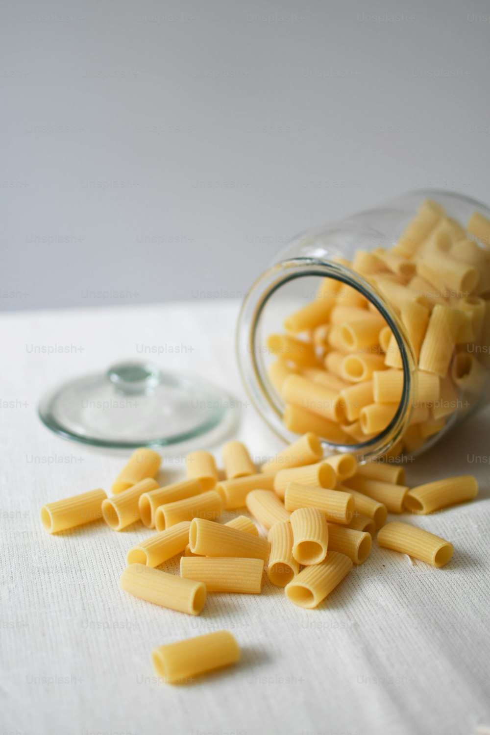 a glass jar filled with pasta noodles on top of a table