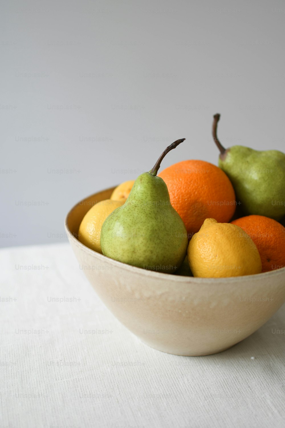 a white bowl filled with fruit on top of a table