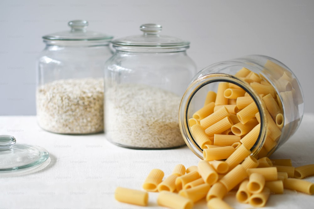 a jar of macaroni and cheese next to two glass jars of macaro