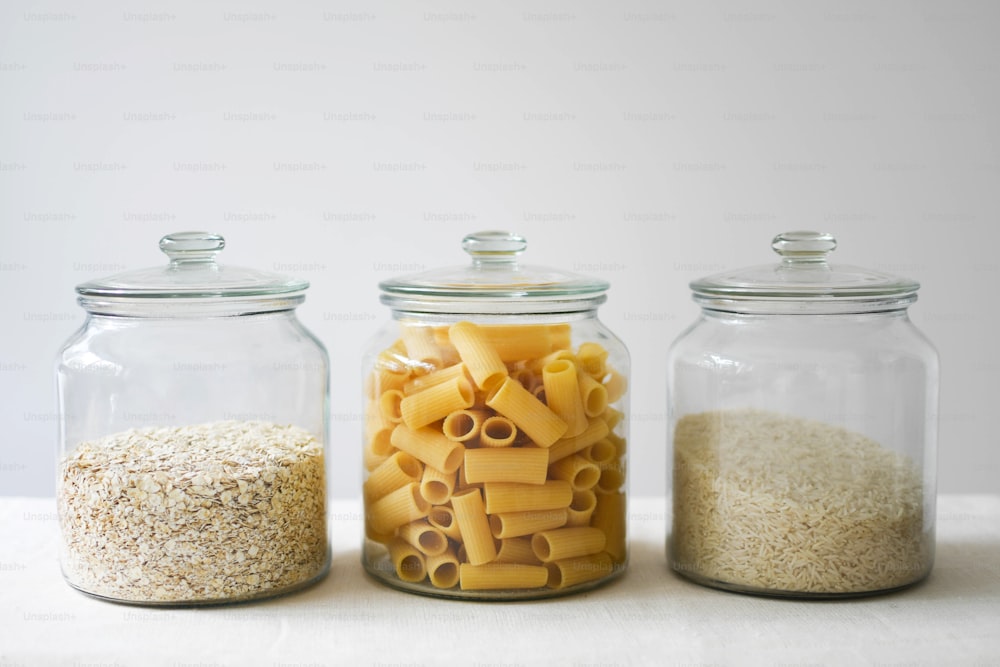 three jars filled with different types of pasta