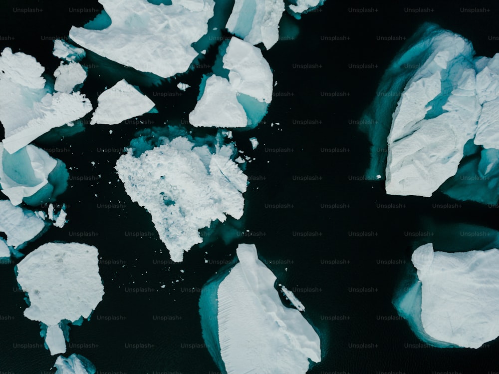 a group of icebergs floating on top of a body of water