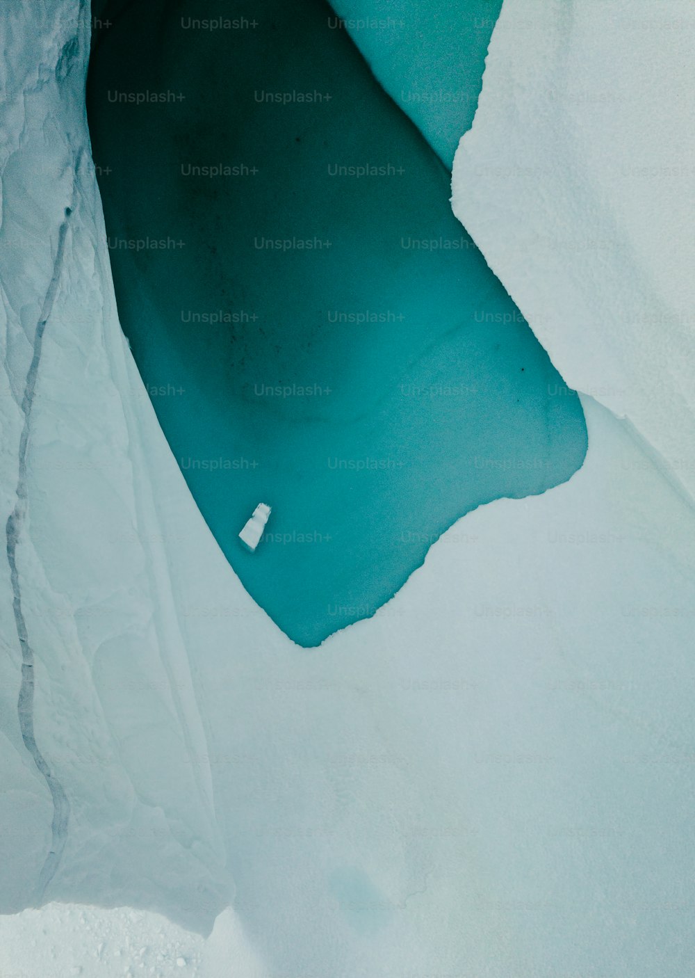 an aerial view of a body of water surrounded by snow