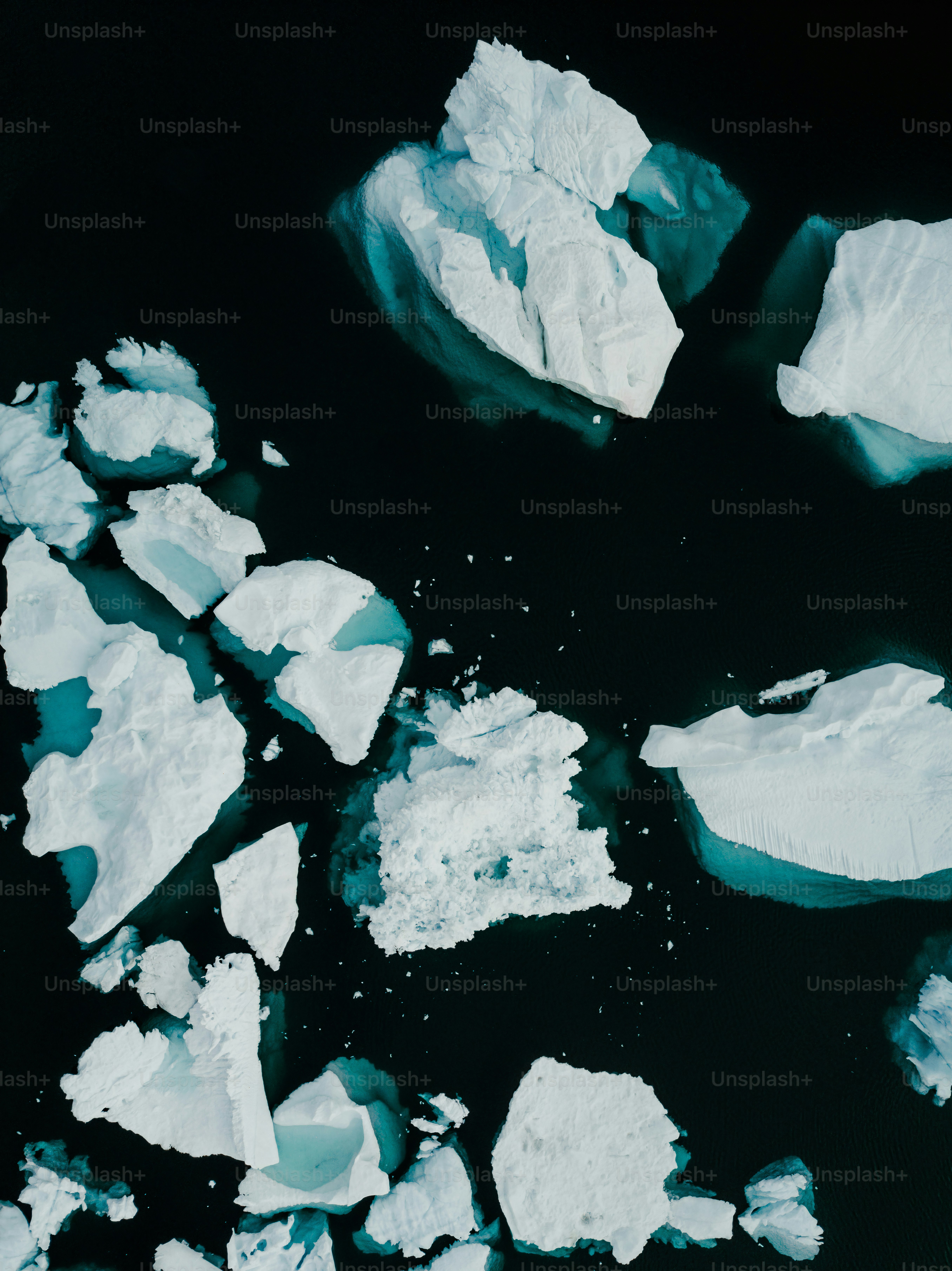 a group of icebergs floating on top of a body of water