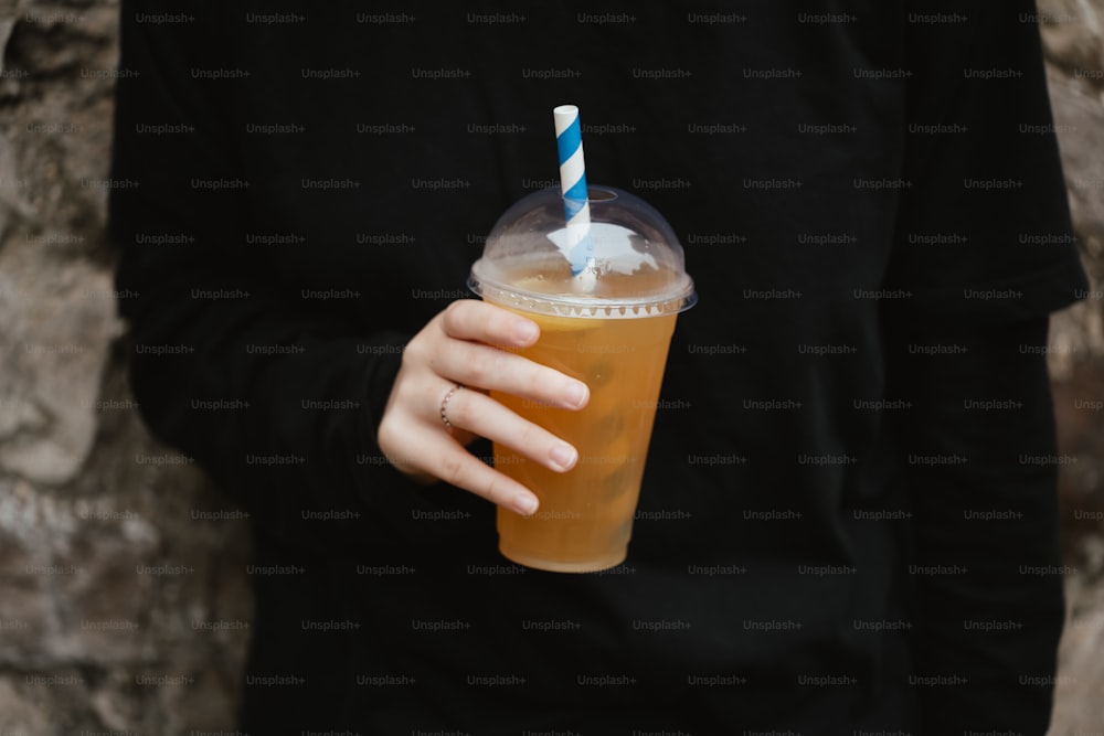 a person holding a drink in their hand