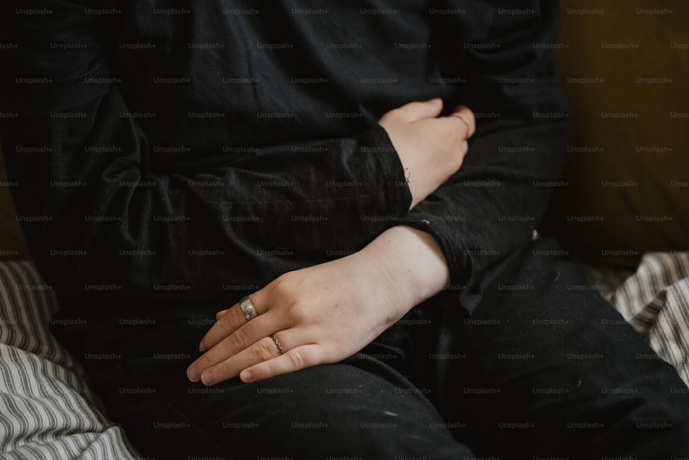 a person sitting on a couch with their hand on their chest