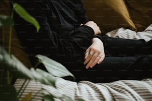 Una mujer sentada en un sofá con las manos sobre las rodillas