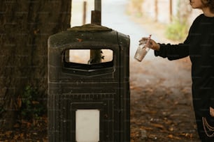 a woman standing next to a trash can