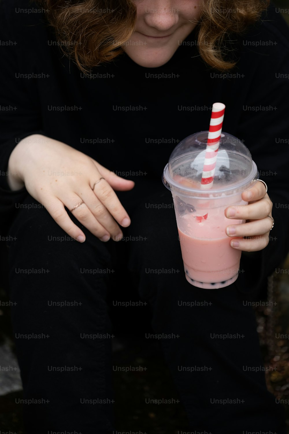 a woman is holding a drink in her hand