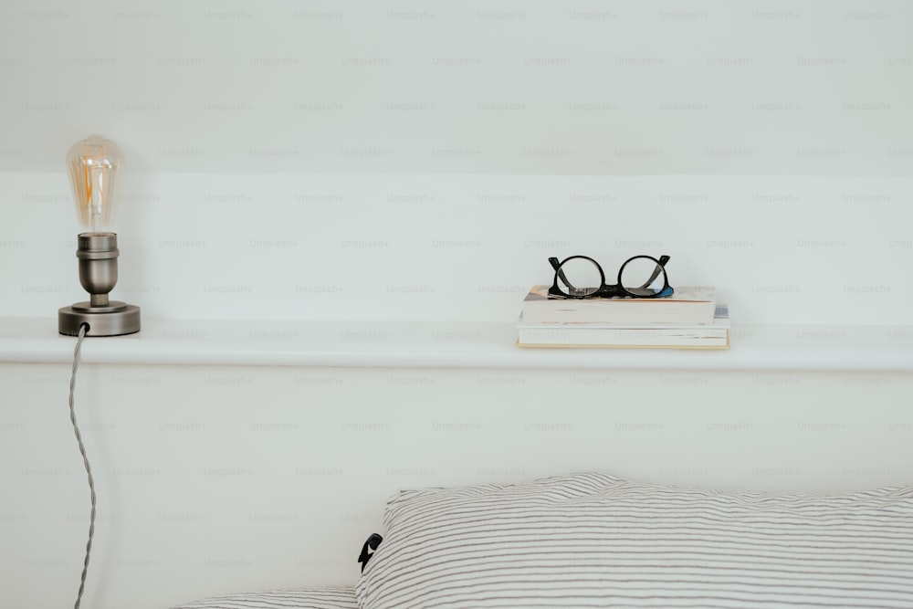 a pair of glasses sitting on top of a book on a bed
