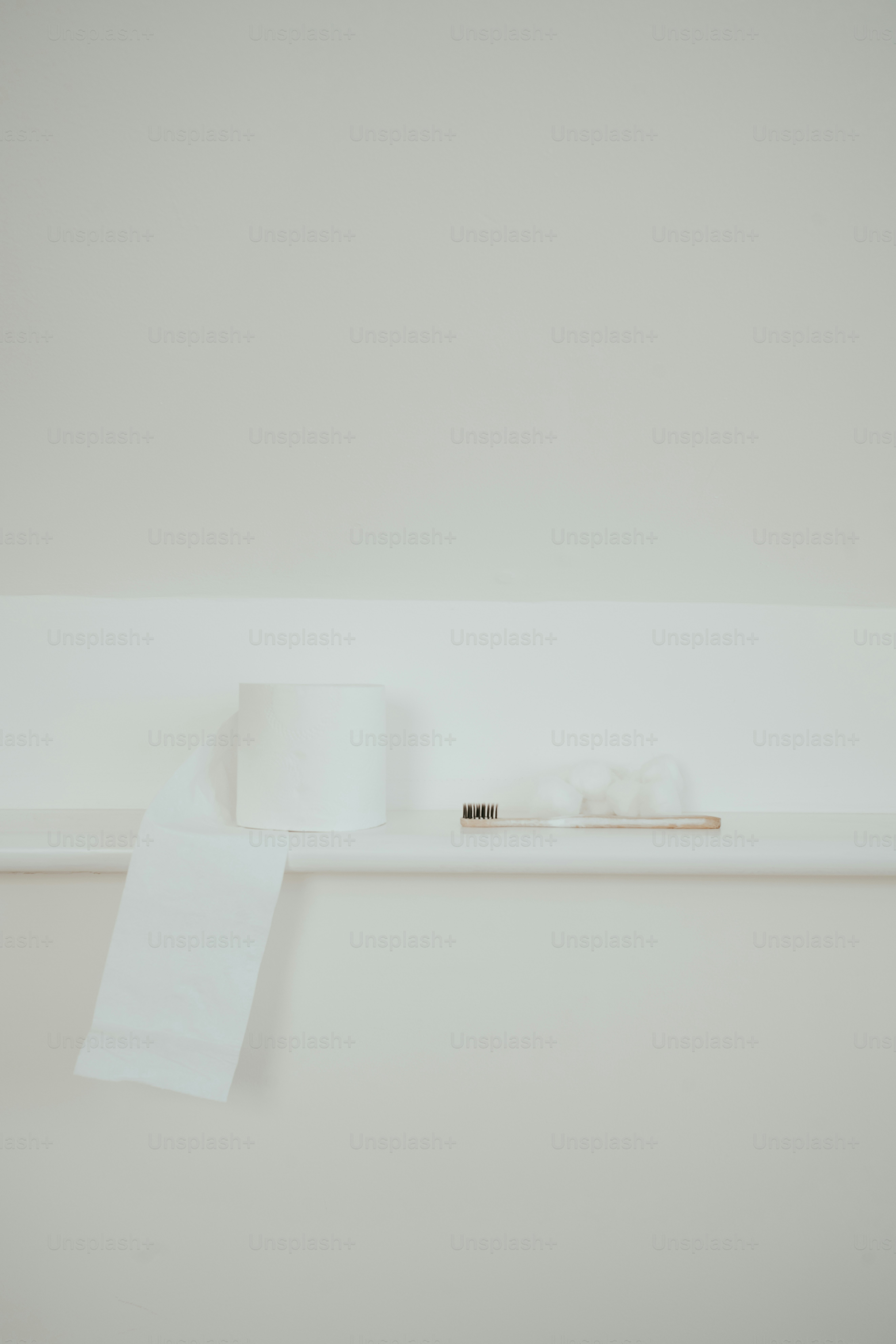 a white shelf with a roll of toilet paper on it