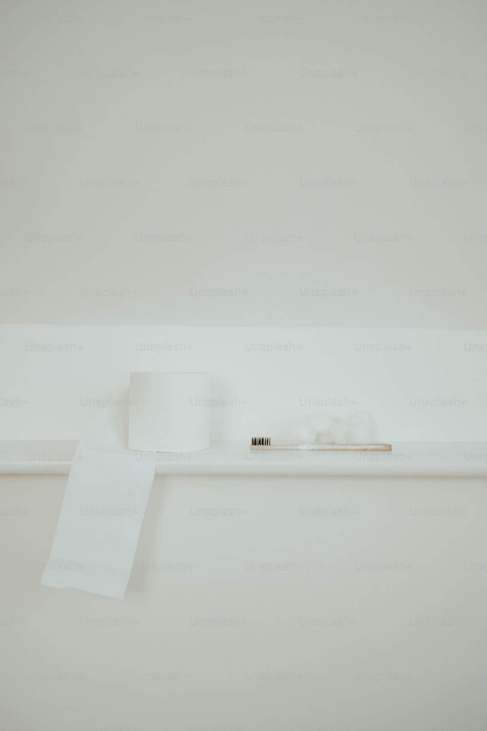 une étagère blanche avec un rouleau de papier toilette dessus