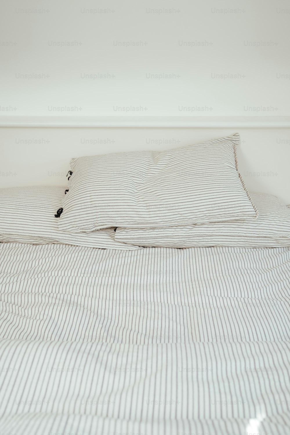a bed with a white and black striped comforter