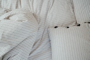 a bed with a striped comforter and two pillows