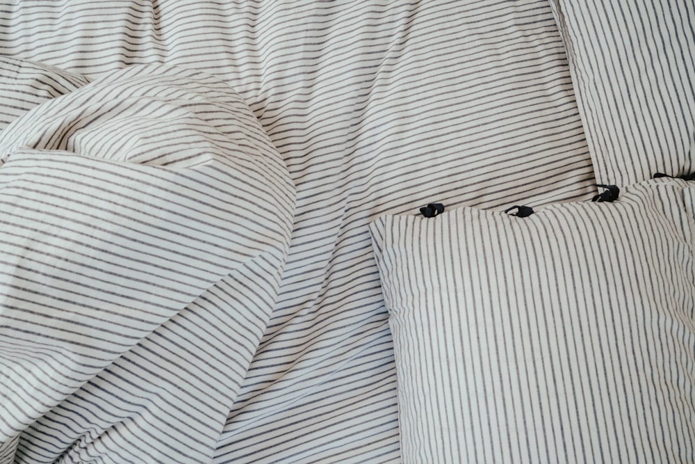 줄무늬 이불과 베개 2개가 있는 침대