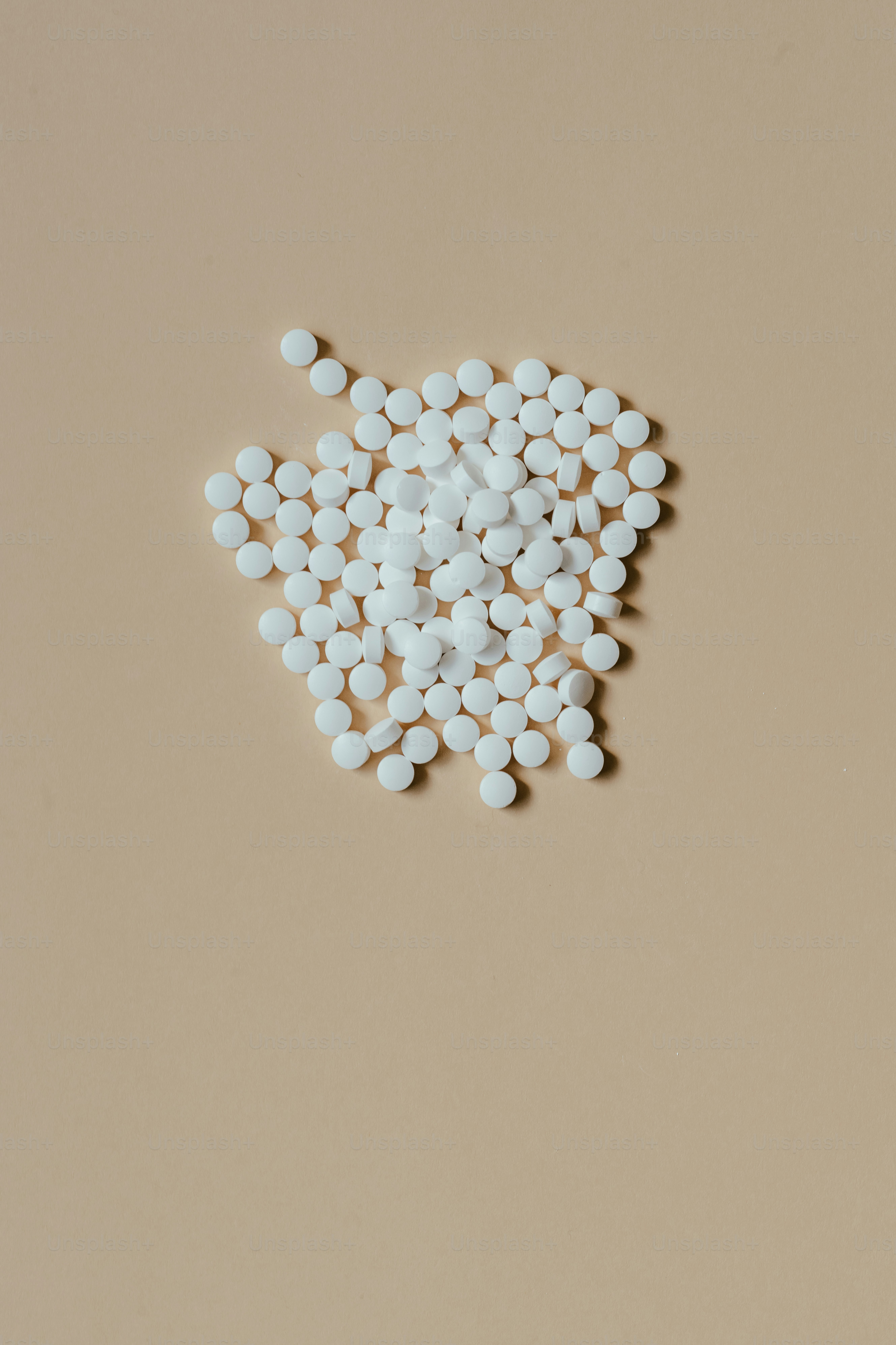 a pile of white pills sitting on top of a table