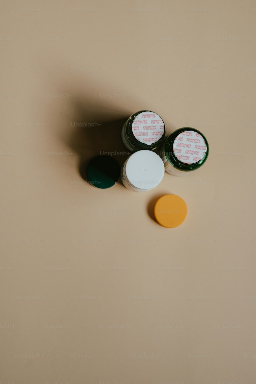 three small jars with lids on top of a table