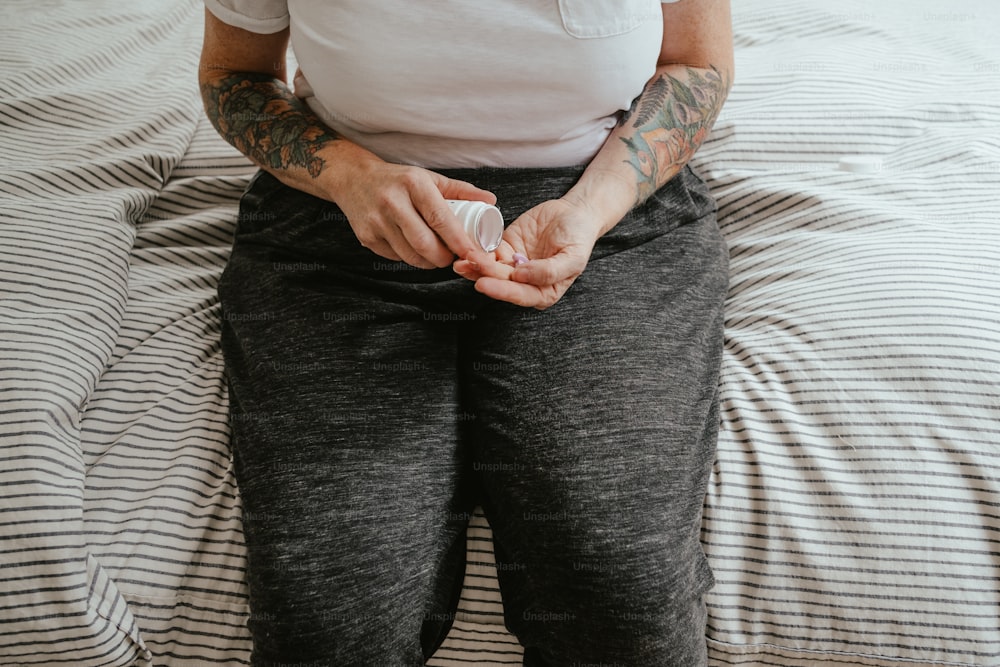 a woman sitting on a bed with her hands in her pockets