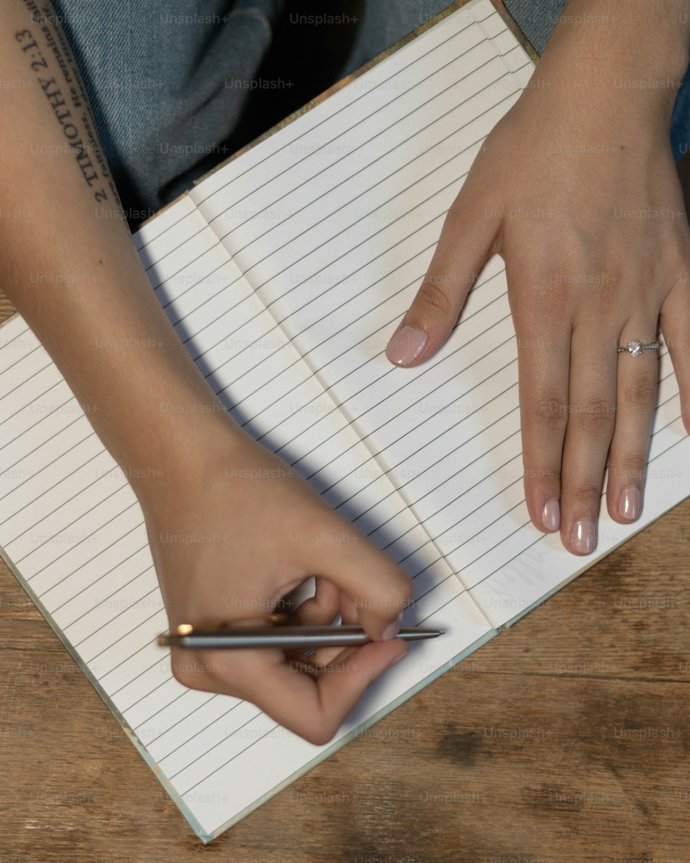 une personne tenant un stylo et écrivant sur un cahier