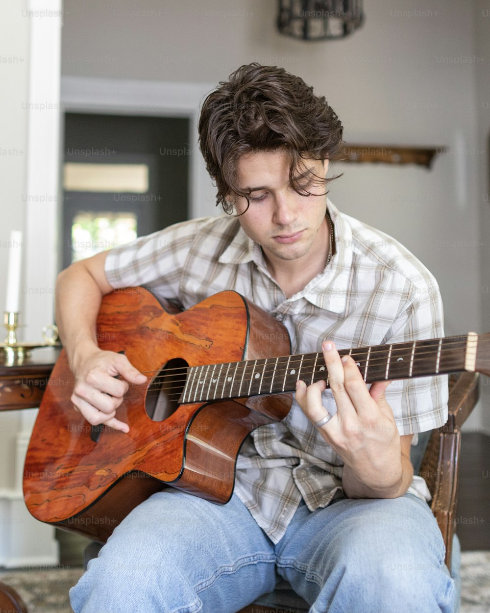 Un hombre sentado en una silla tocando una guitarra