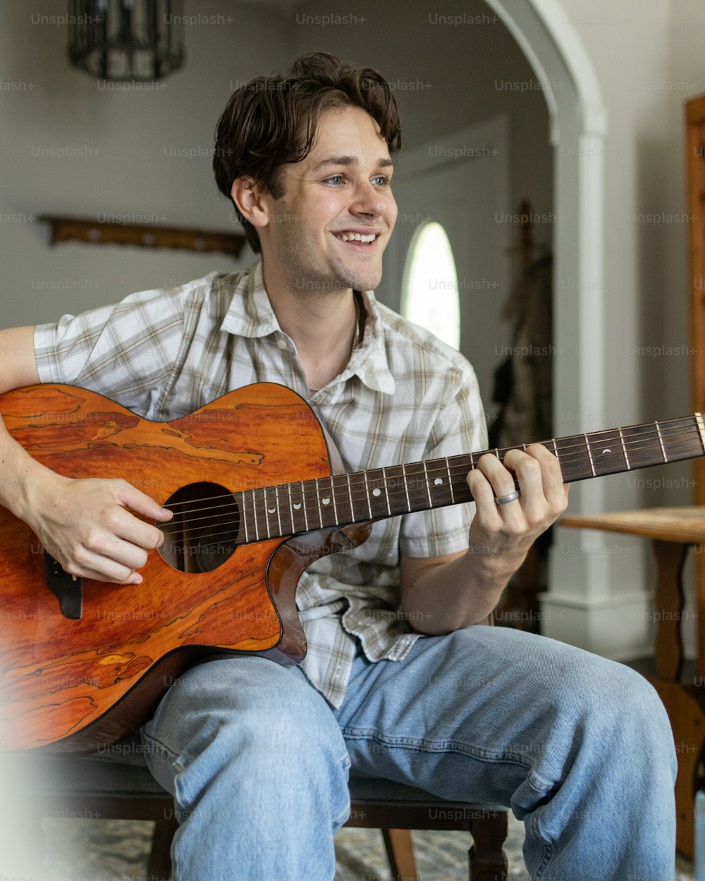 a man sitting on a chair playing a guitar