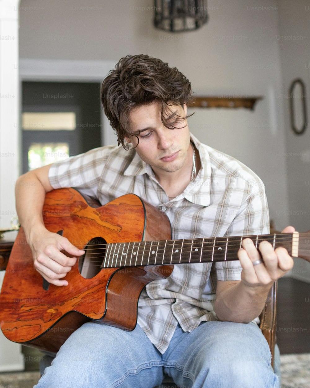 a man sitting on a chair playing a guitar