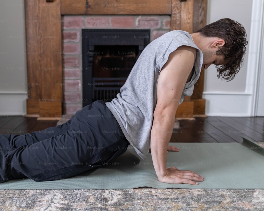 a man is doing a yoga pose in front of a fireplace