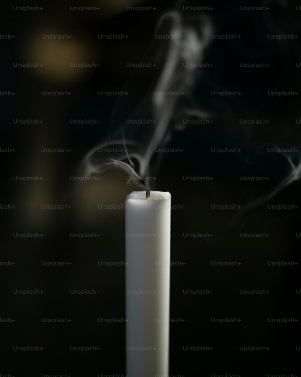 uma vela branca com fumaça saindo dela