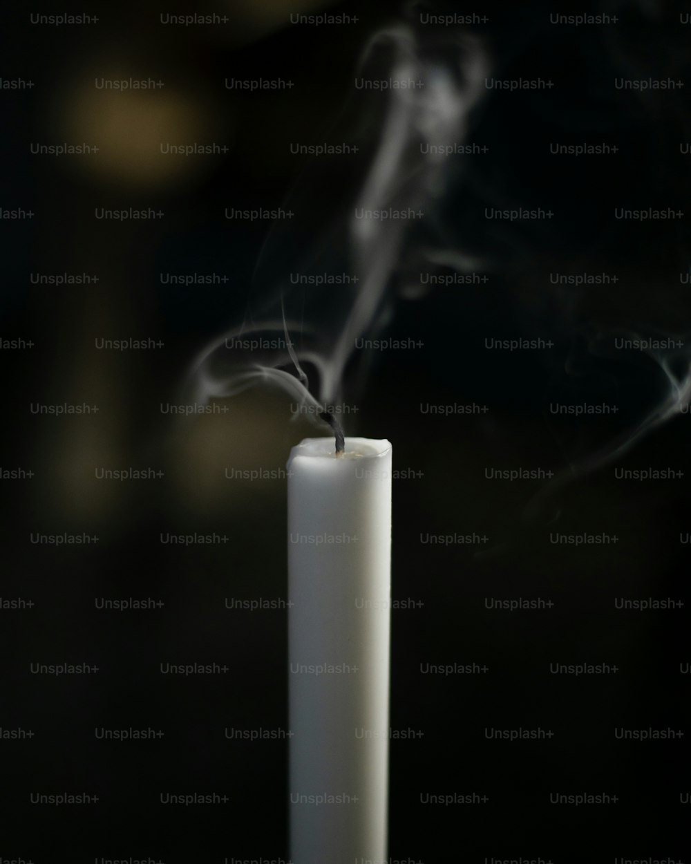 a white candle with smoke coming out of it