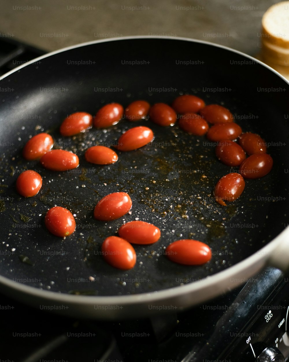 a pan filled with hot dogs on top of a stove