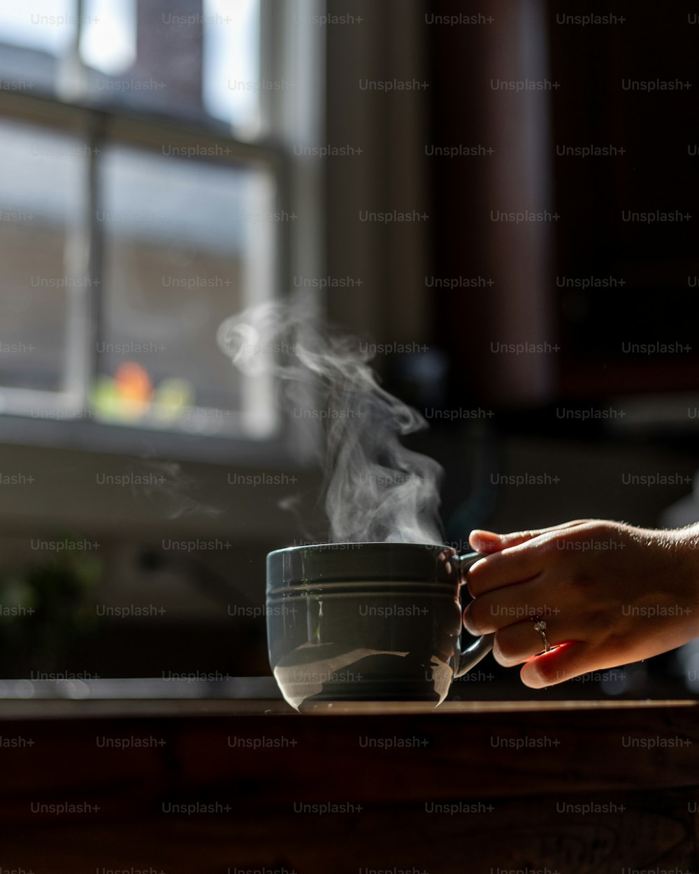 a person holding a cup with steam coming out of it