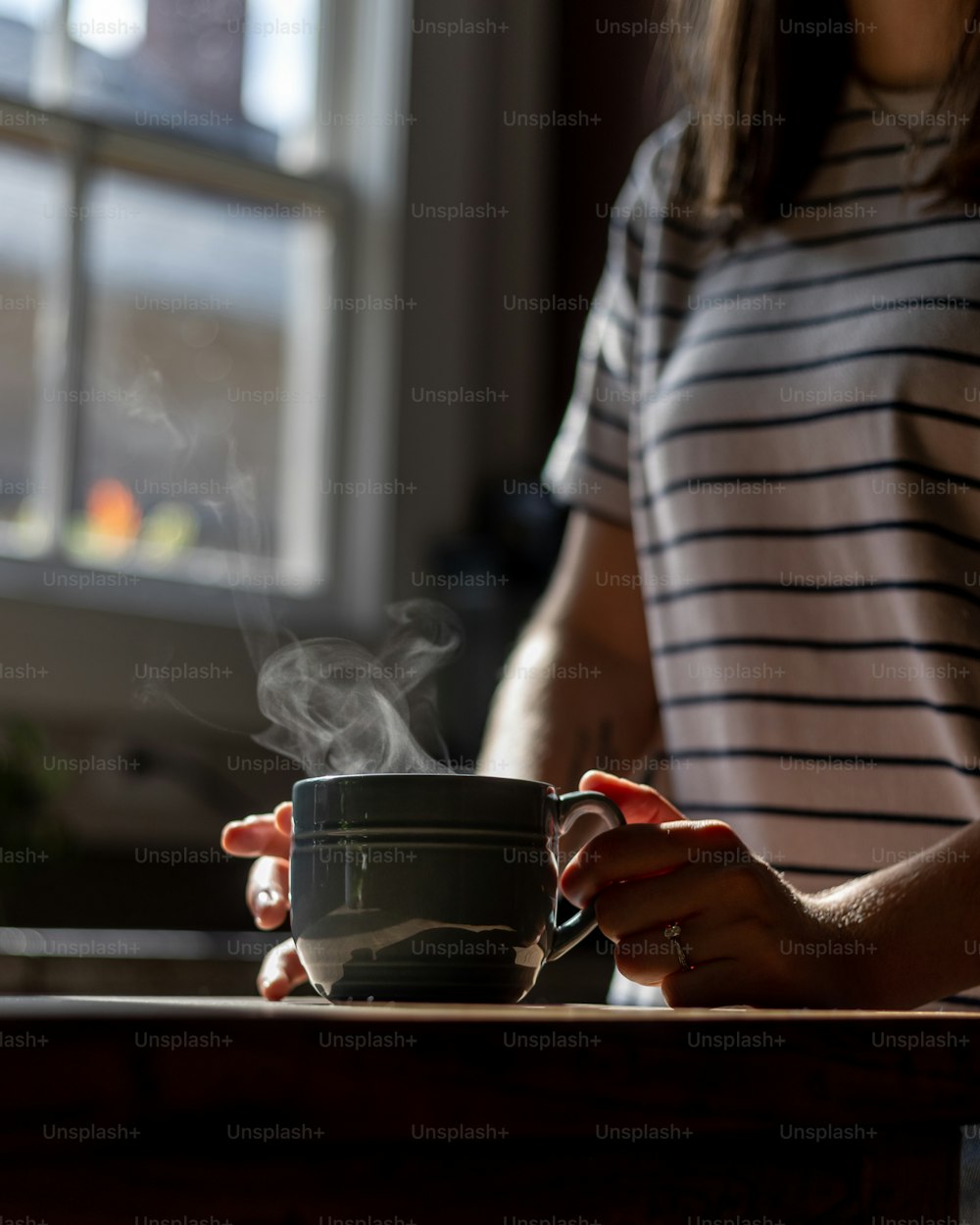 a woman holding a cup of hot coffee
