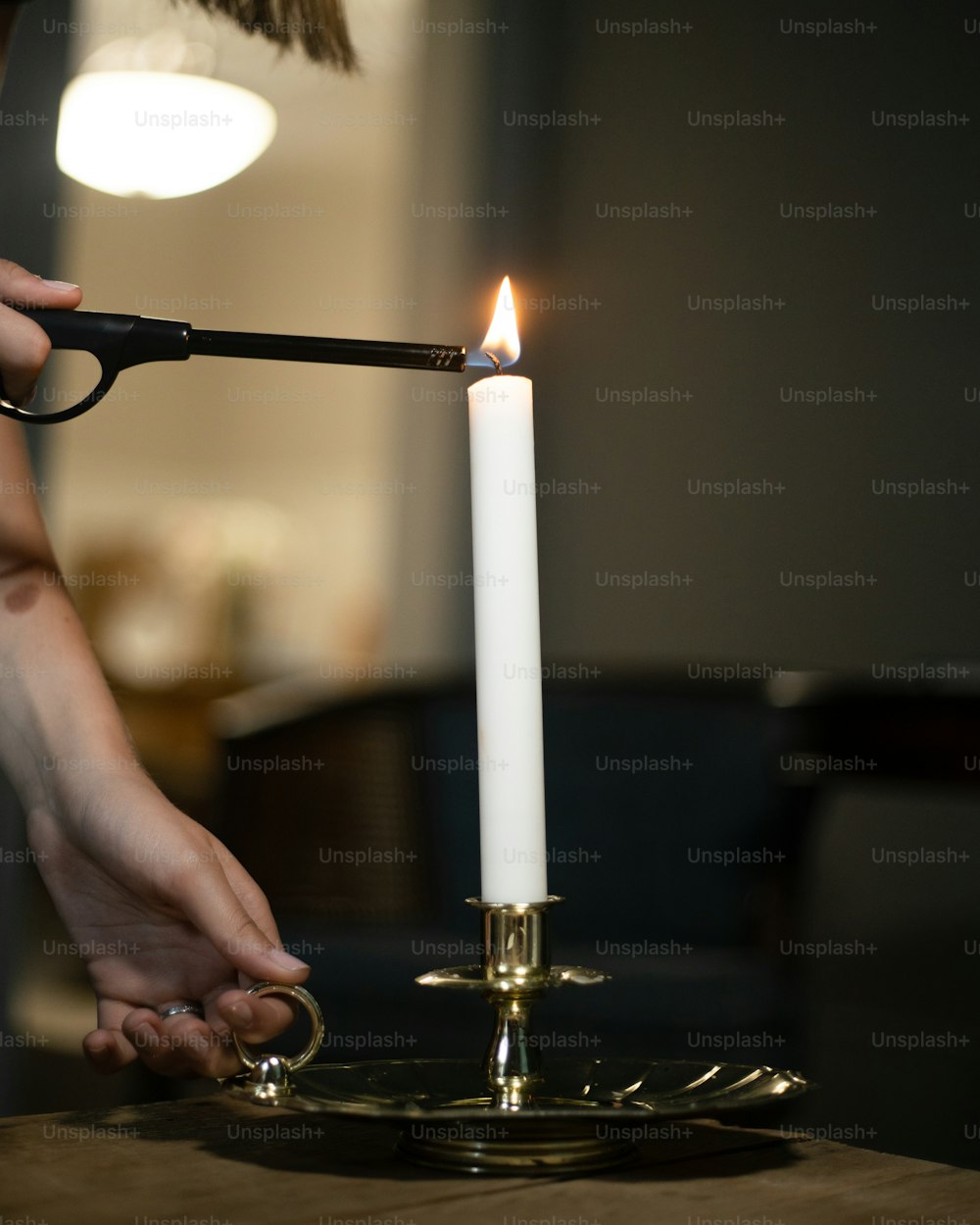eine Person, die eine Kerze auf einem Tisch anzündet