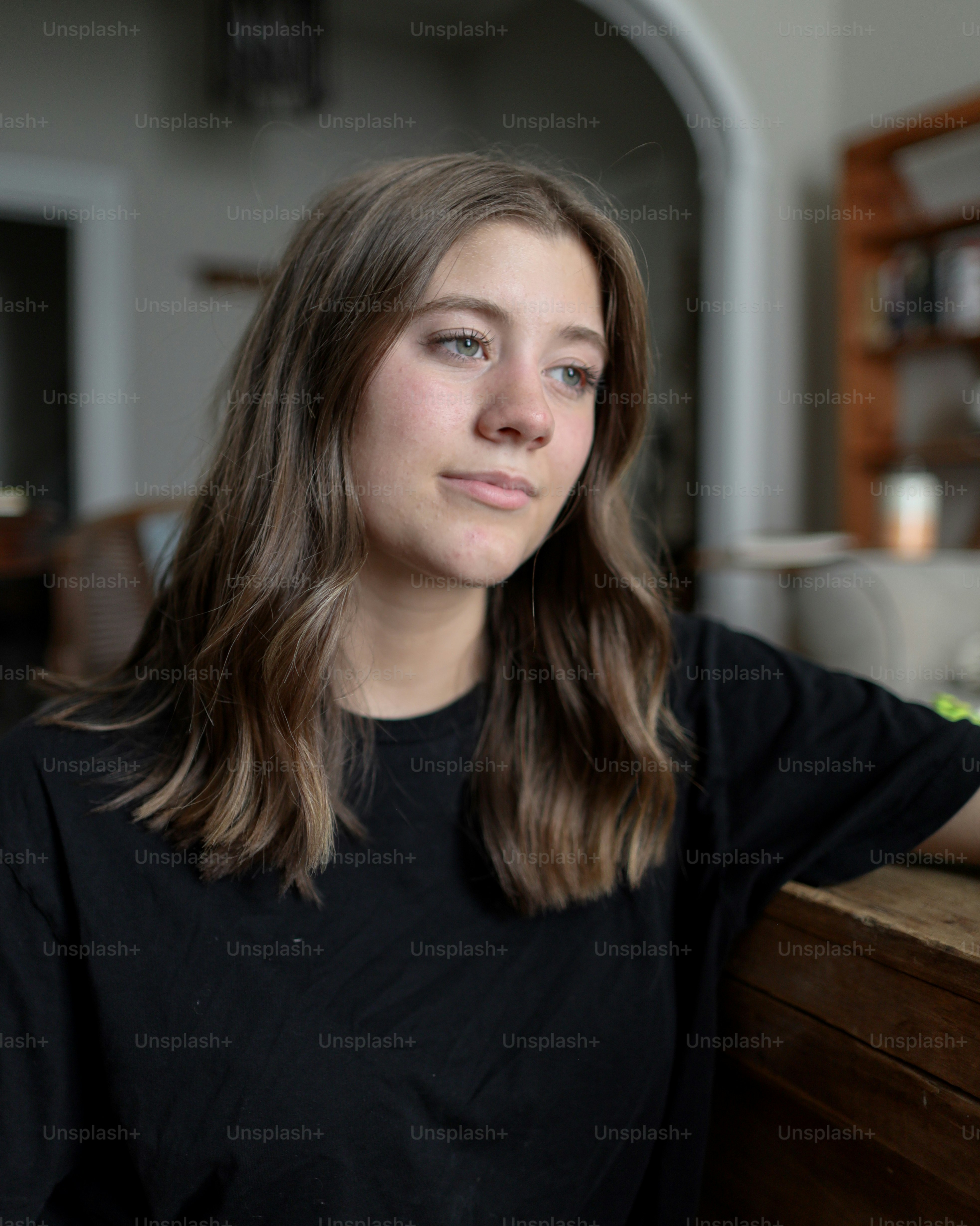 a woman with long hair standing next to a counter