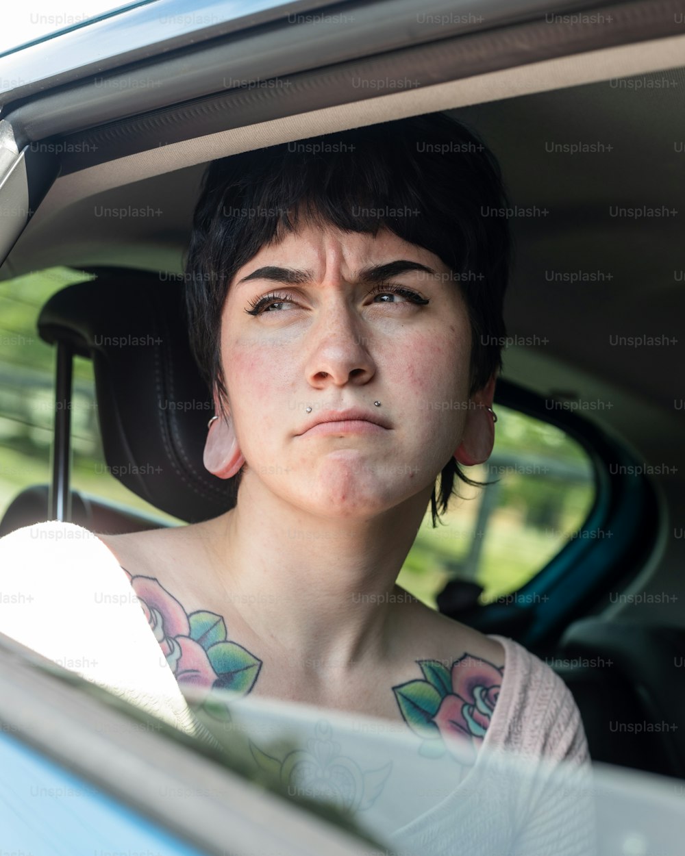 Una donna seduta in una macchina che guarda fuori dal finestrino