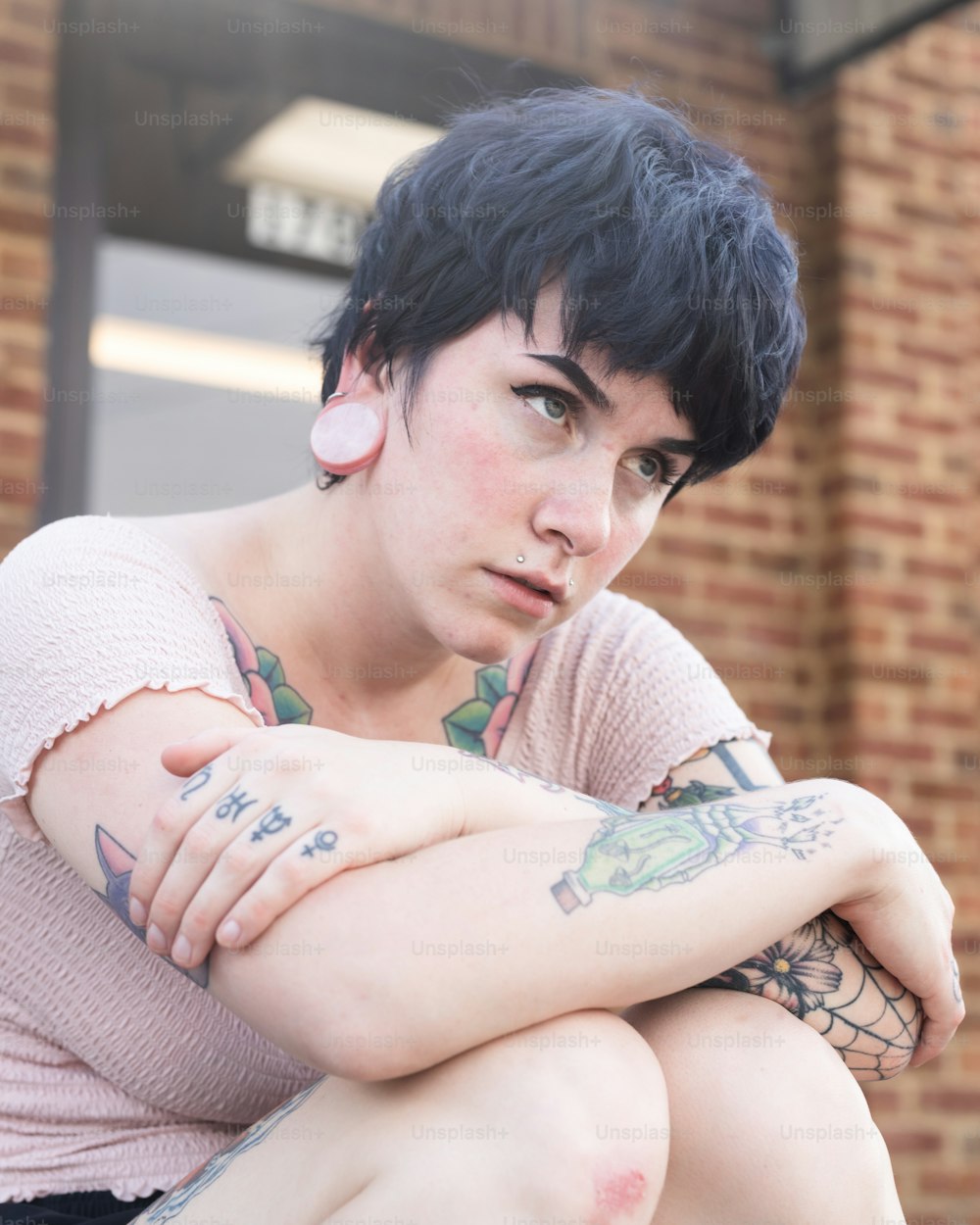 a woman with tattoos sitting on a bench
