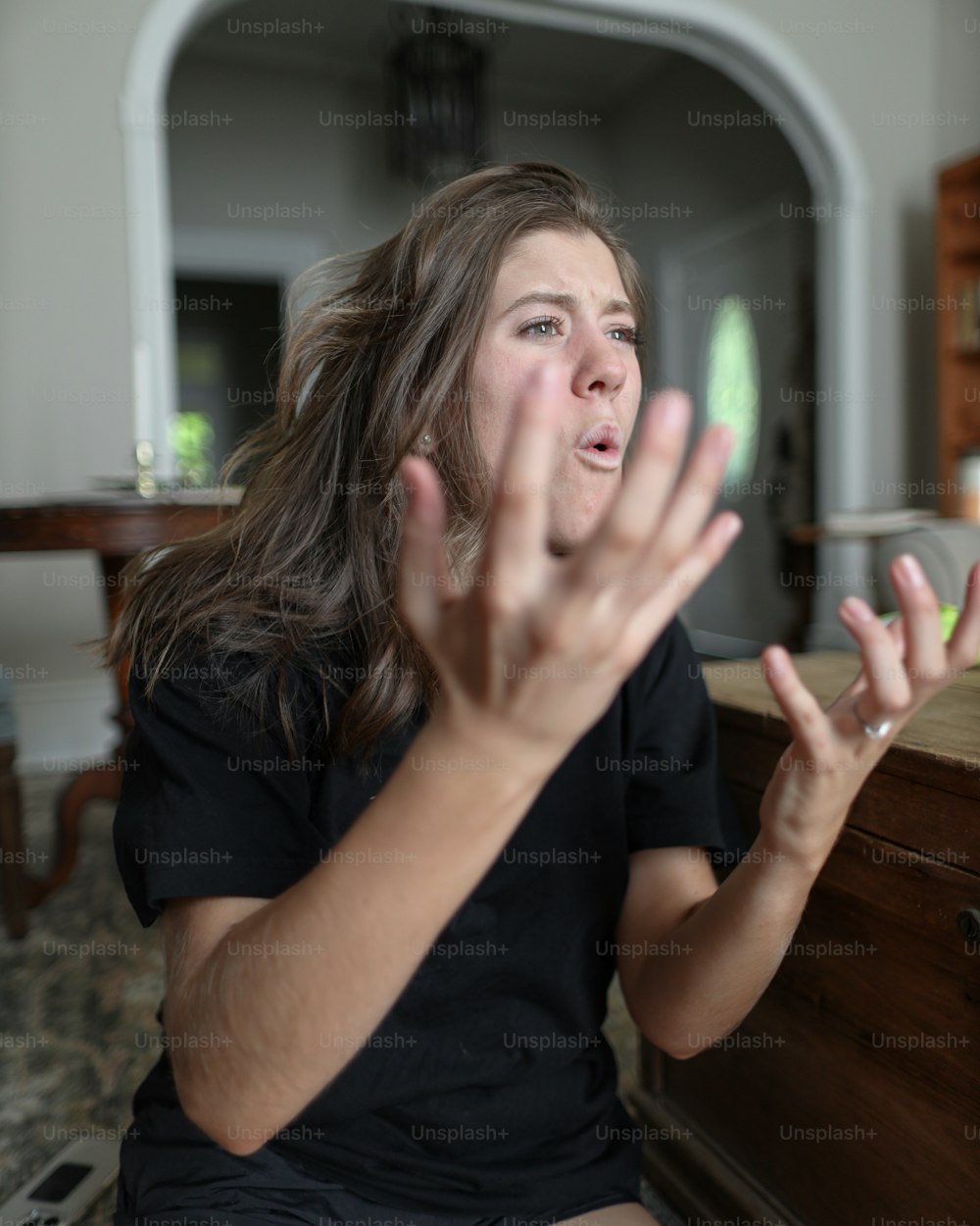 a woman sitting on the floor with her hands in the air