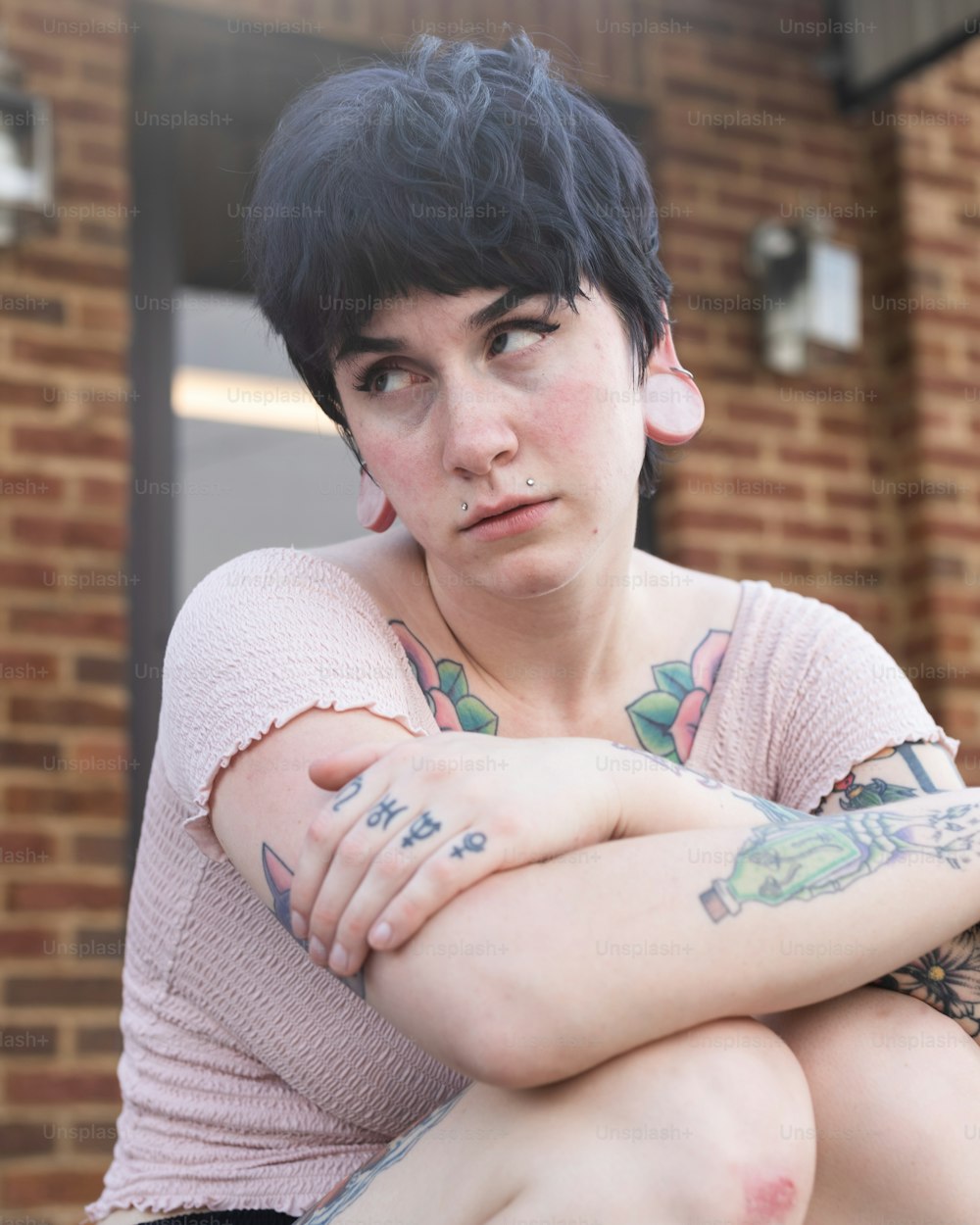 Eine Frau mit Tätowierungen, die auf einer Bank sitzt