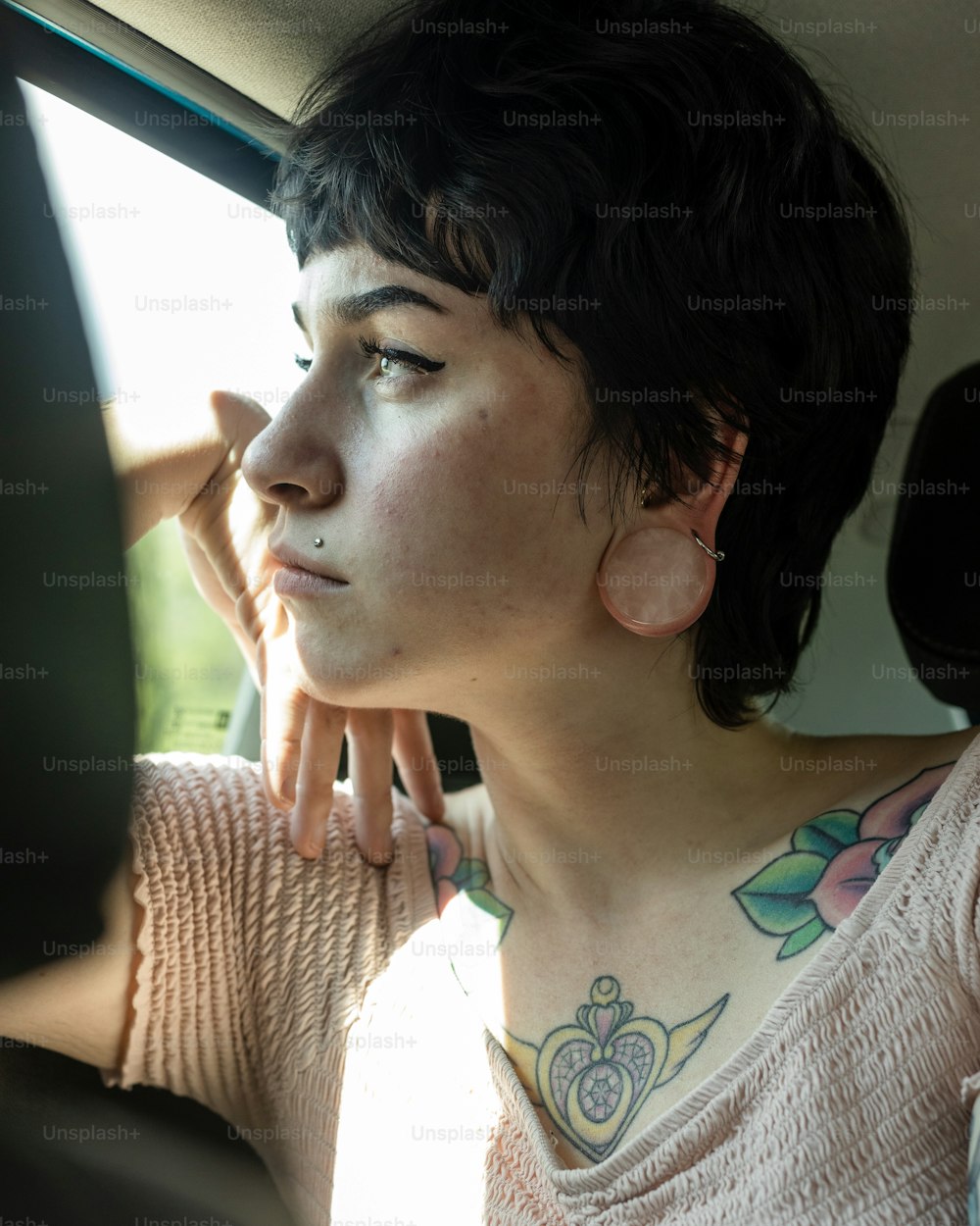 a woman sitting in a car with a cigarette in her mouth