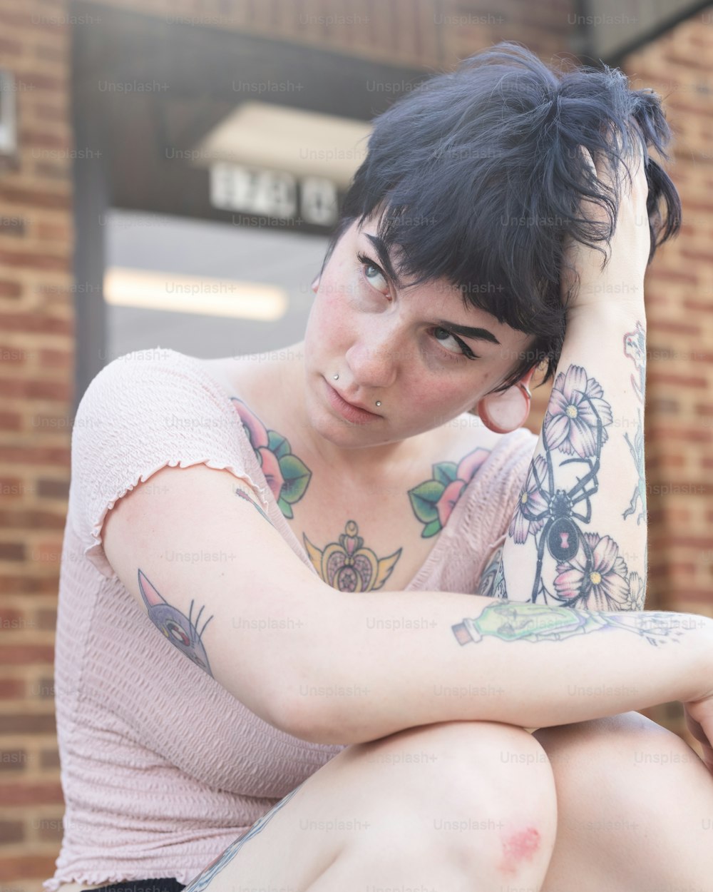 Una mujer con tatuajes sentada en un banco