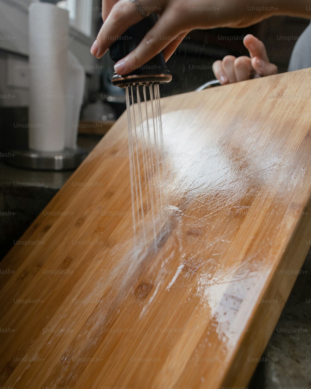 une personne se lave les mains sur un comptoir en bois