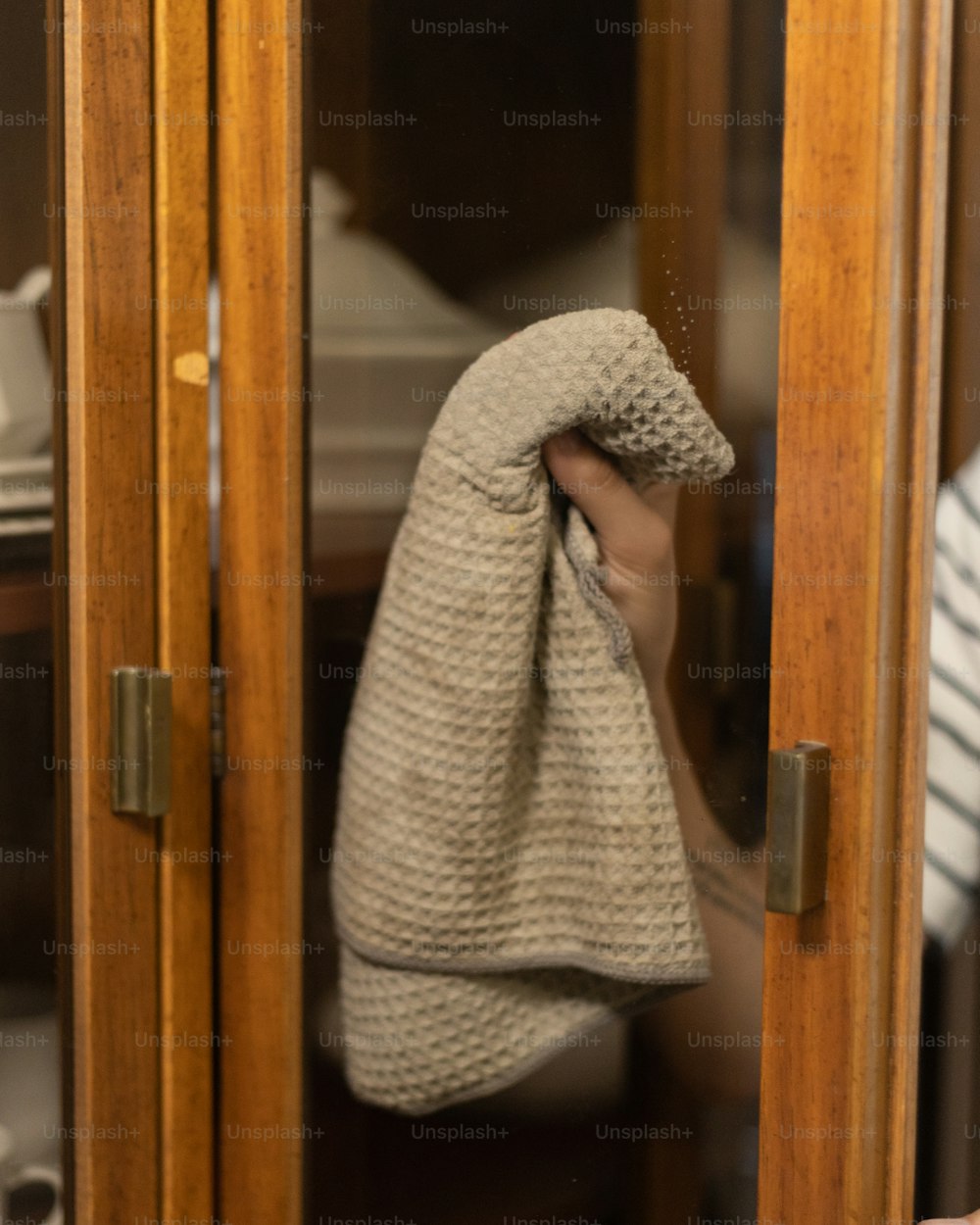 una persona sosteniendo una toalla frente a un espejo