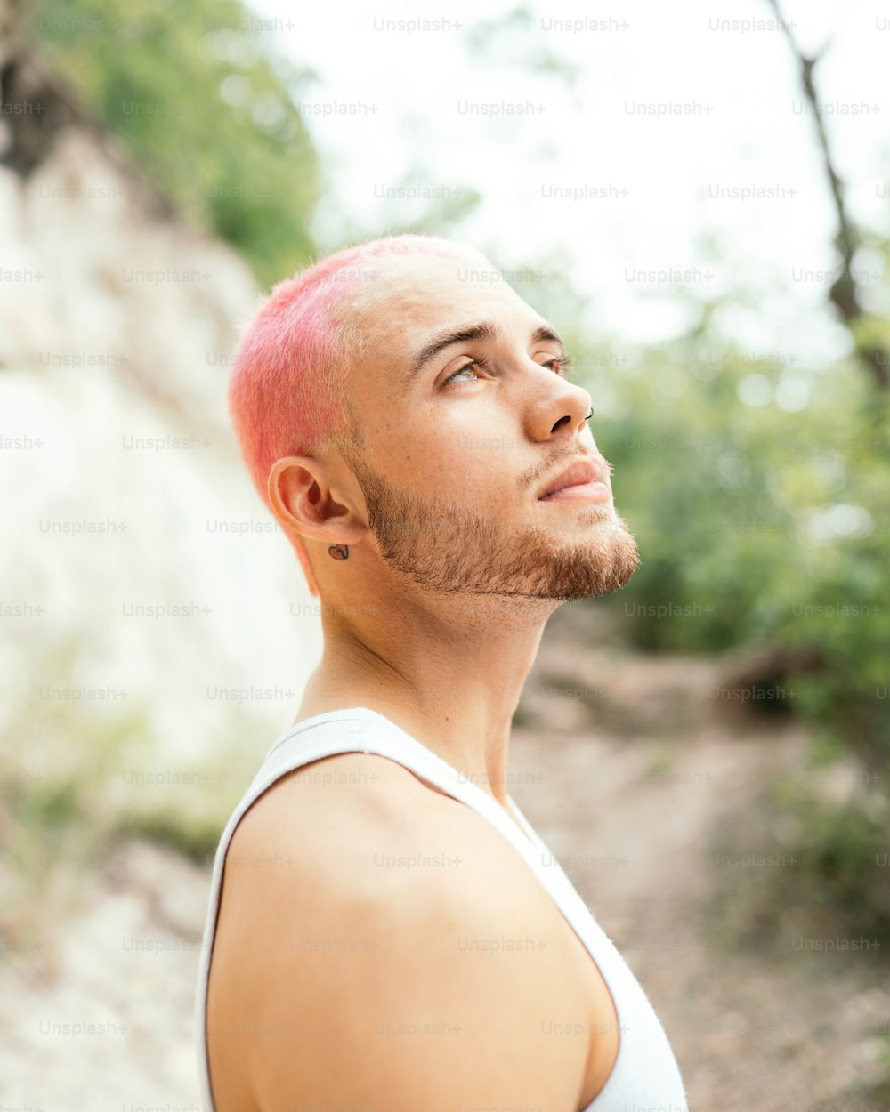 a man with pink hair looking up at the sky