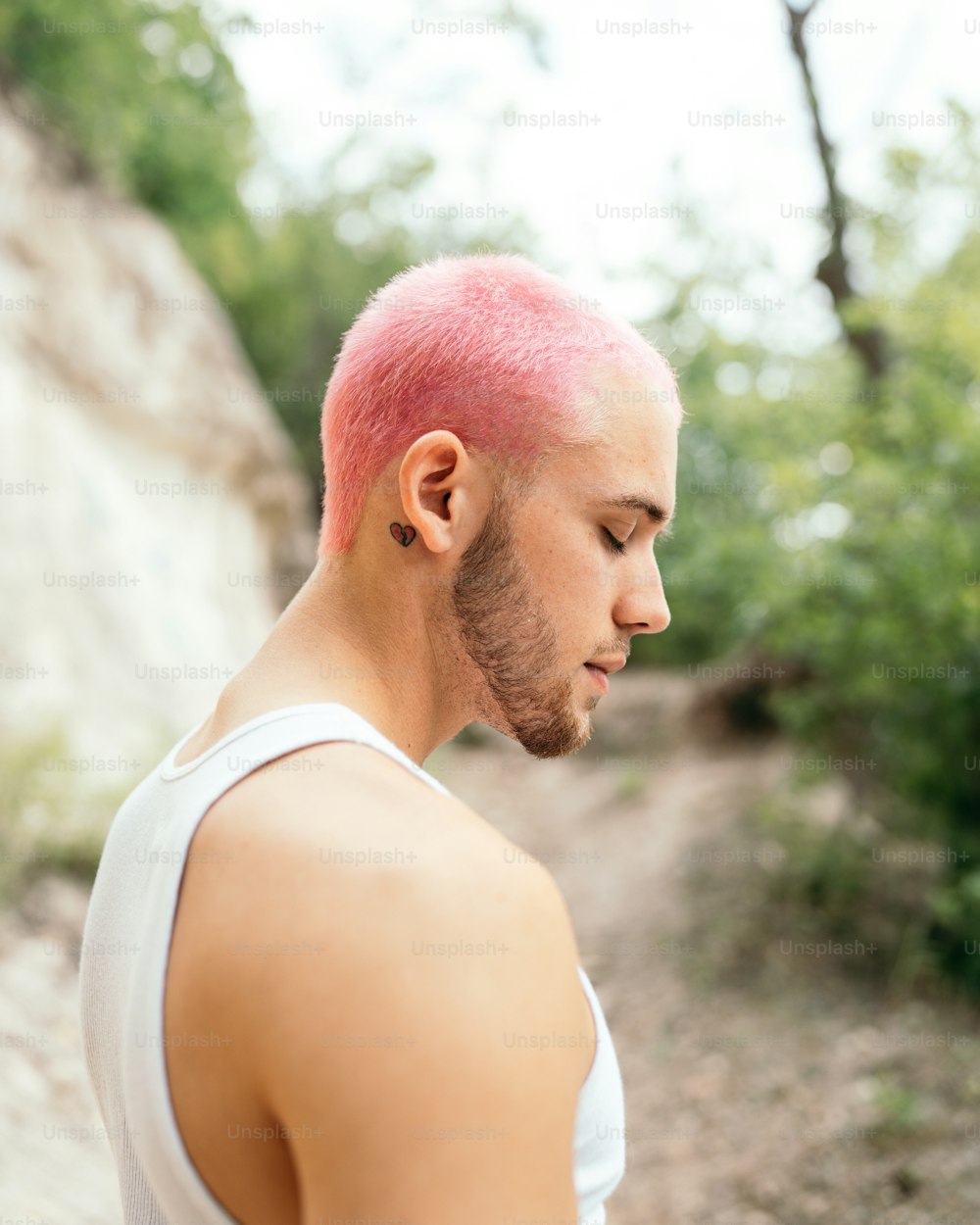 a man with pink hair and a white tank top