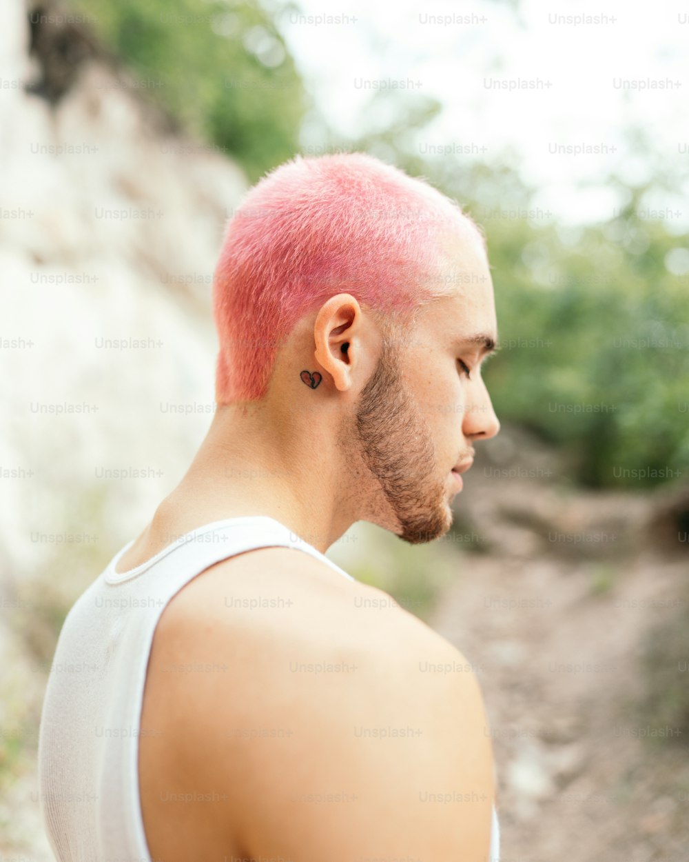 a man with a pink mohawk and a white tank top
