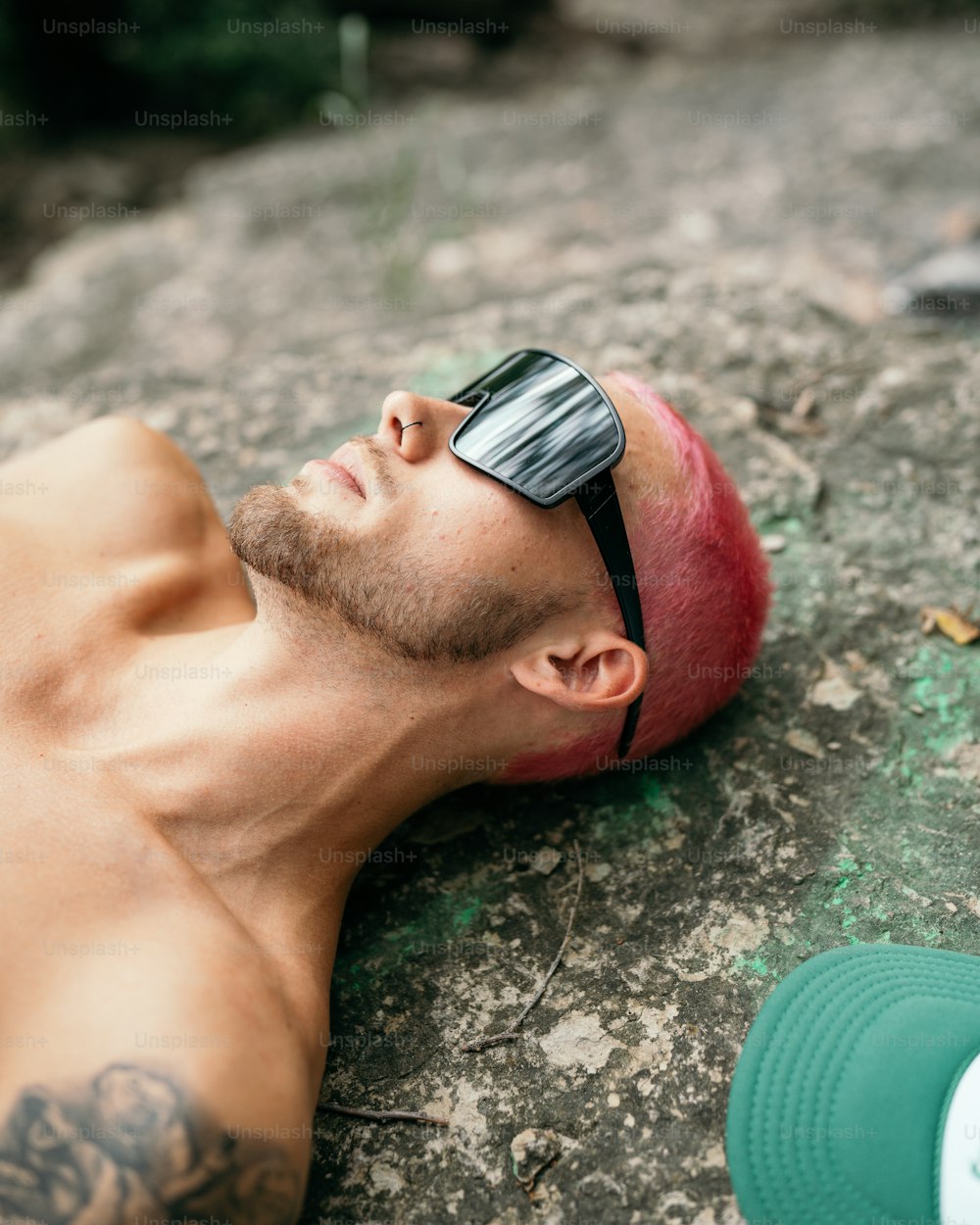 a man laying on the ground wearing sunglasses