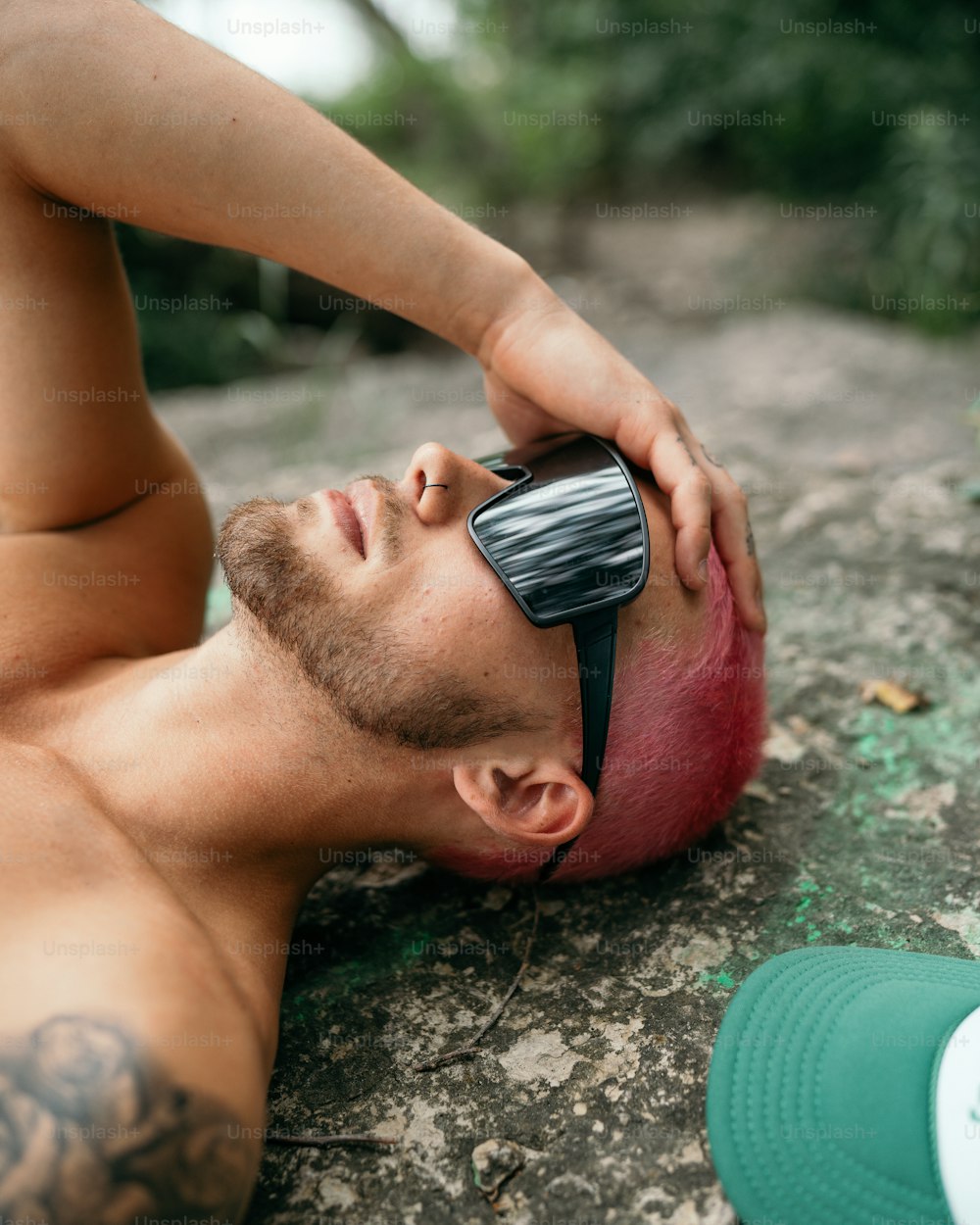 a man laying on the ground with a pair of sunglasses on his face