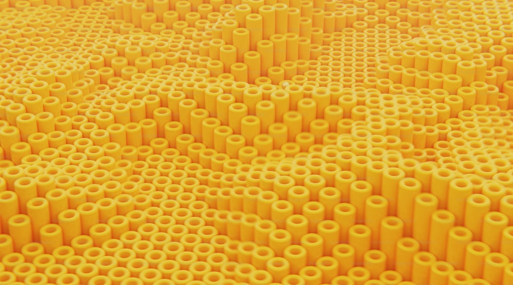 une grande quantité de tubes jaunes sont disposés selon un motif