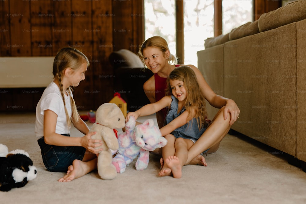 a group of girls sitting on the floor with stuffed animals