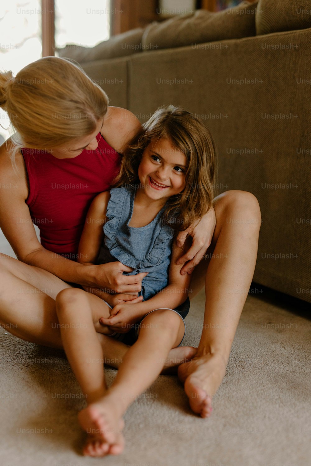 a woman and a little girl sitting on the floor