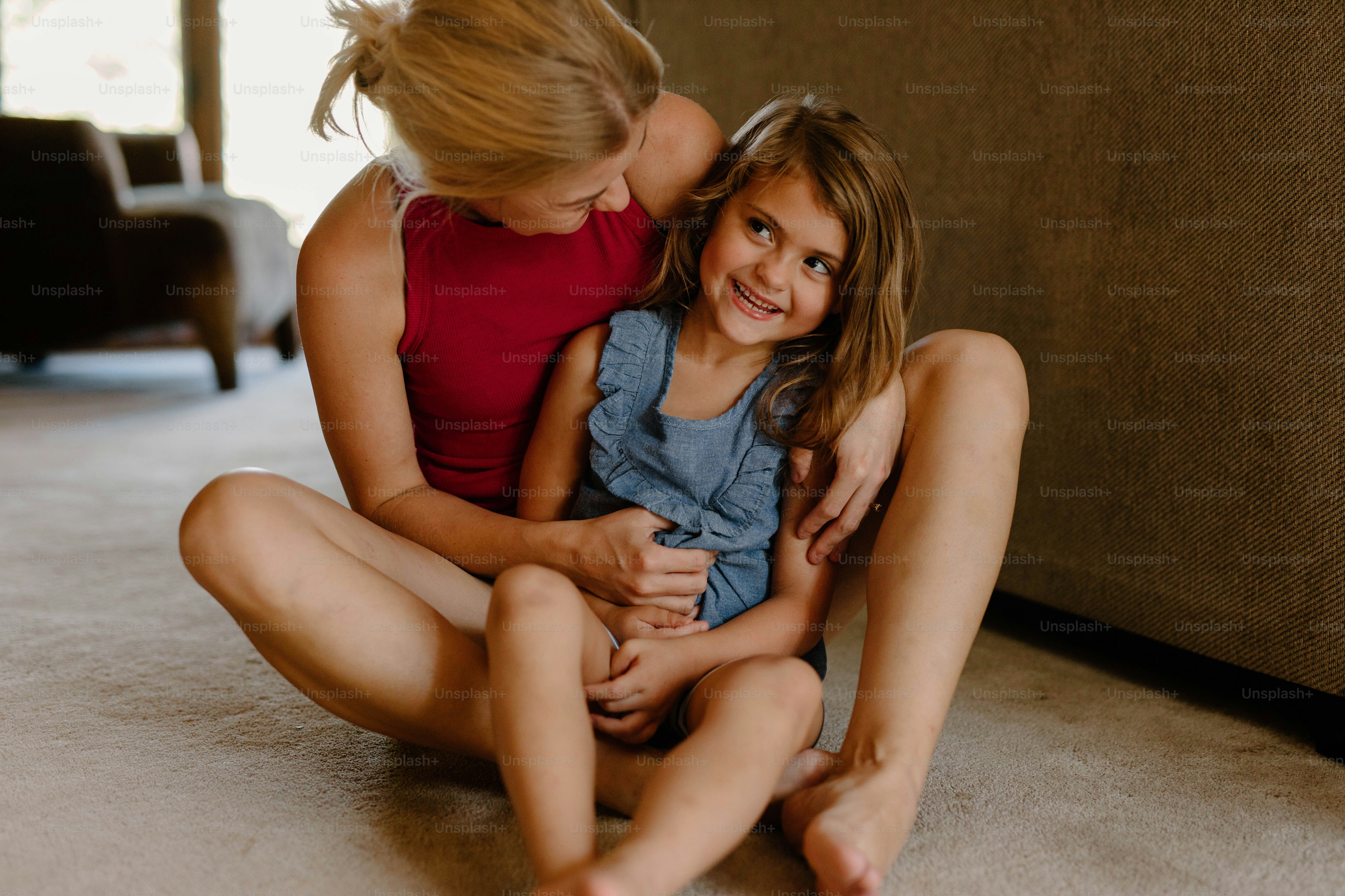 a woman and a little girl sitting on the floor